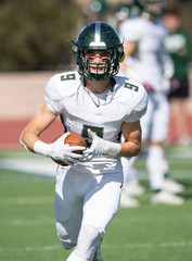 Action photo of athletic football player making amazing play during a football game
