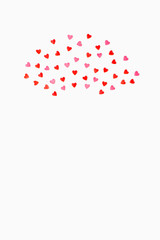small sweet hearts lie in a semicircle on a white background. vertical photo. Flat lay. Copy space.