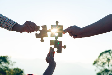 Closeup hands, connected hands, puzzle, support teamwork with sunshine, business vitality, success...