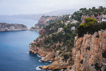 Beautiful super wide-angle aerial view of Xabia, Javea, Marina Alta with harbor and skyline, mountains, beach and city, seen from Cabo de San Antonio viewpoint, province of Alicante, Valencia, Spain