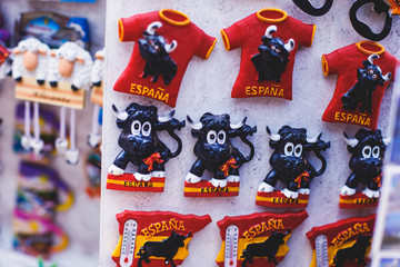 View of traditional tourist souvenirs and gifts from Spain, Alicante, Valencia with toys, bull...