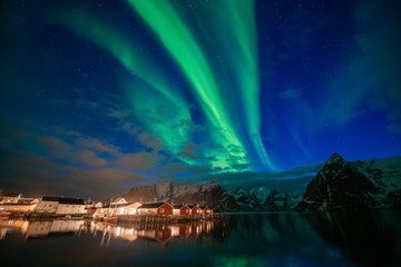 Fototapeta na wymiar Aurora borealis on the Lofoten islands, Norway. Green northern lights above mountains. Night sky with polar lights. Night winter landscape