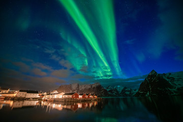 Aurora borealis on the Lofoten islands, Norway. Green northern lights above mountains. Night sky with polar lights. Night winter landscape