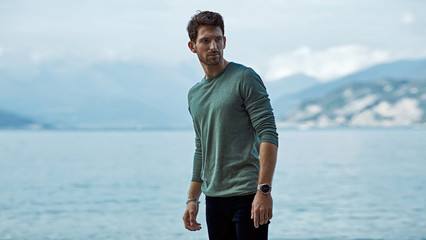 Handsome man in casual style clothes over lake and alps view
