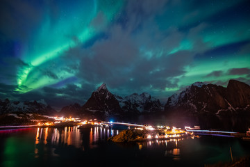 Naklejka na ściany i meble Aurora borealis on the Lofoten islands, Norway. Green northern lights above mountains. Night sky with polar lights. Night winter landscape