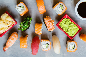 Top view on traditional japanese empty with sushi, ginger, soy sauce, wasabi on concrete gray background, mock up, flat lay. Online food delivery concept