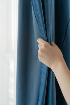 woman hand opening the curtains