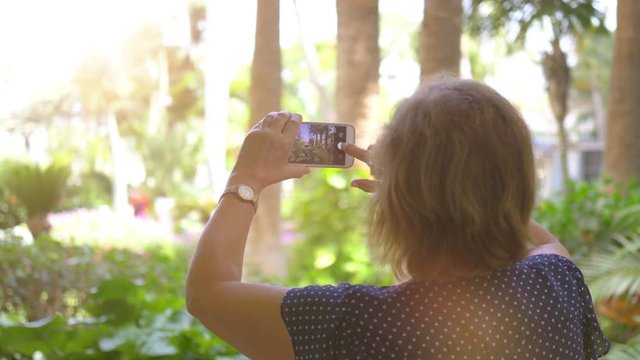 Senior woman taking picture by smartphone in 4K Slow motion 60fps