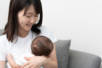 Obraz na płótnie Canvas 赤ちゃんを抱いた若い女性