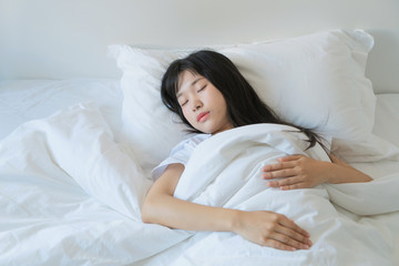 Fototapeta na wymiar asian Young beautiful woman sleeping in her bed and relaxing in the morning