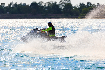 A man ride jet ski in the river with water splash.