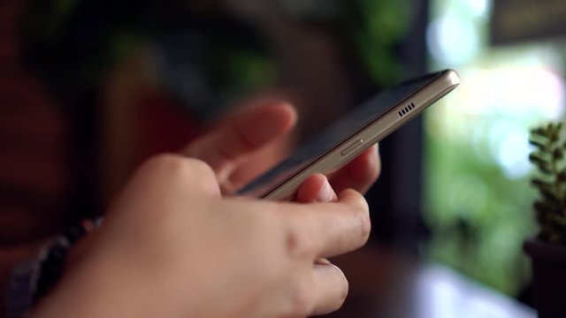 4k video People hand using smartphone with blur cafe shop background. Business, financial, trade stock maket and social network concept.