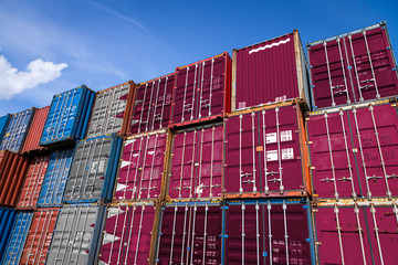 The national flag of Qatar on a large number of metal containers for storing goods stacked in rows...