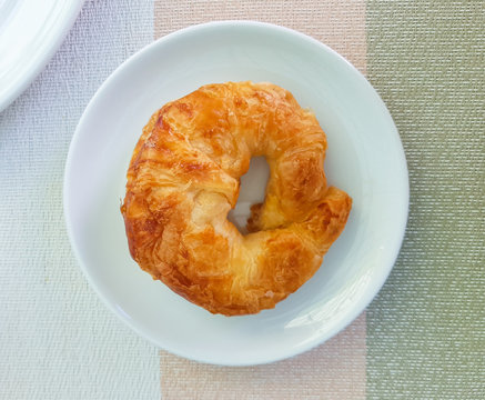 Fresh crossiant isolated on white plate.