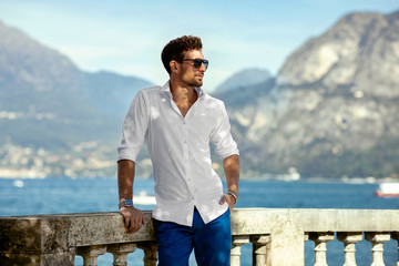 Handsome man relaxing outdoor over alps mountains background 