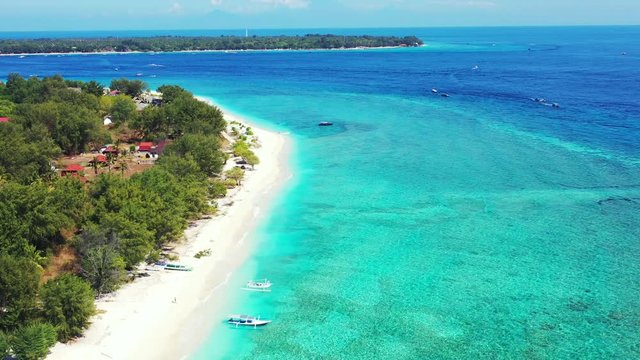 Hanimaadhoo Island, Maldives - Beautiful Scenery Of Lush Green Island With Boats Docked On The Sandy Shore Surrounded By Crystal Clear Sea - Aerial Shot