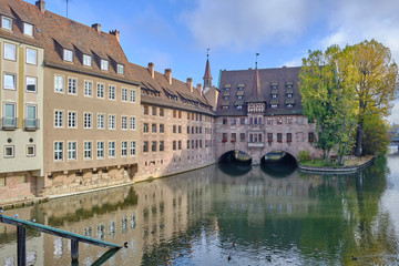 Fototapeta na wymiar Scenic view of Pegnitz river between old houses in Nuremberg - second-largest city of federal state of Bavaria in Germany. Beautiful summer sunny look of small river in ancient city in Europe