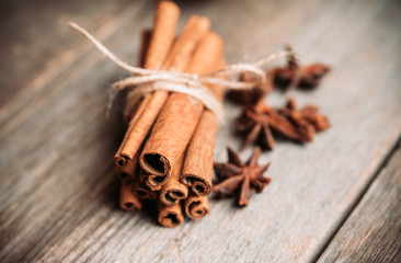 Bundle of cinnamon and anise stars on the rustic wooden background. Selective focus. Shallow depth of field.