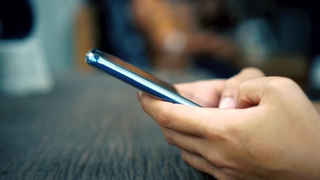 4k video People hand using smartphone with blur cafe shop background. Business, financial, trade stock maket and social network concept.