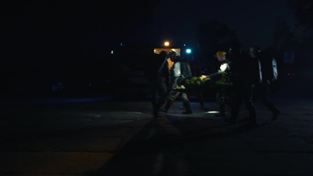 rescuers load a man in an ambulance