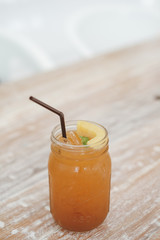 Fresh homemade peach iced tea with mint on a wooden table