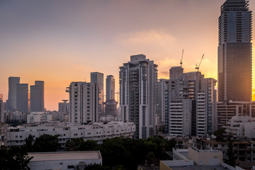 Fototapeta na wymiar Aerial sunset panorama view of Tel Aviv financial district, Givatayim, , Givat Amal, Tel Binyamin, Givat Rambam, Montefiore with skyscrapers and cranes working on new construction in Israel