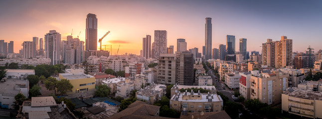 Aerial sunset panorama view of Tel Aviv financial district, Givatayim, , Givat Amal, Tel Binyamin, Givat Rambam, Montefiore with skyscrapers and cranes working on new construction in Israel