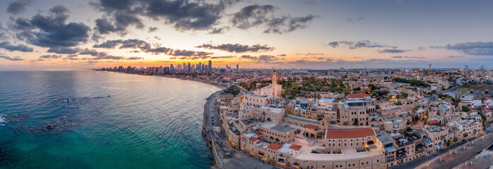 Aerial view of Tel Aviv Yafo along the Mediterranean sea at predawn with colorful sky over the city...