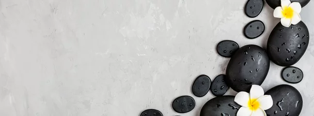 Keuken spatwand met foto Bovenaanzicht van hot spa-stenen voor massagebehandeling op grijze betonnen achtergrond met kopieerruimte. Elegante en luxe spa. Plat leggen, overhead, mock-up, sjabloon. Gezondheids- en schoonheidsverzorging concept © Алина Бузунова