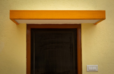 View of a exterior room door and the slab above it. Minimalist design.