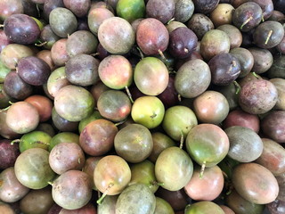 Multicolored fruits of ripe passion fruit sold in the market.