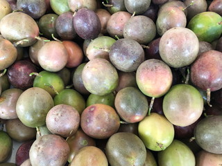 Multicolored fruits of ripe passion fruit sold in the market.