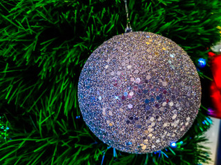 Closeup photo of glitter ball on Christmas tree