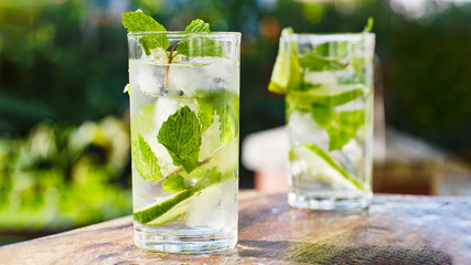 two mojito cocktails on wooden table top