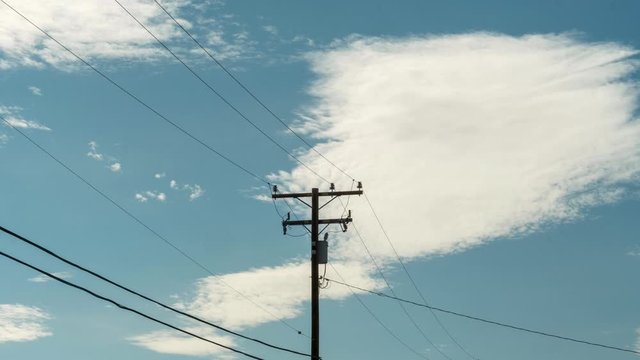 Beautiful White Clouds In Clear Blue Skies Rolling Above Power Lines - Time Lapse