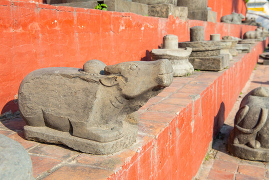 Group of ancient antiques such as Nandi (bull), Yoni and Linga collected in Pashupatinath temple a famous and sacred Hindu temple complex on the banks of the Bagmati River in Kathmandu, Nepal.