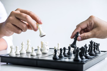 Businessman and businesswoman playing chess and thinking about strategy crash overthrow the opposite team and development analysis for win and successful