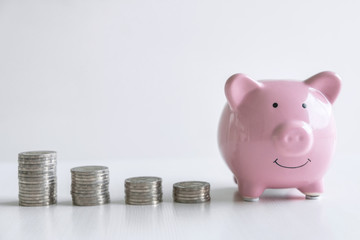 Images of stacking coins pile and pink smiling piggy bank to growing and savings with money box, Saving money for future plan and retirement fund concept