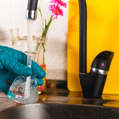 water purification specialist tap water pours into a glass flask.