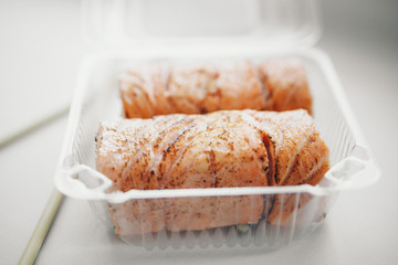 Japanese cuisine: rolls in a plastic container. Sushi on white background. Advertising concept of traditional Oriental cuisine, fish food: salmon, tuna, rice