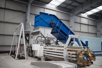 Horizontal hydraulic press for recyclable materials against the wall of a building