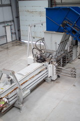 Horizontal hydraulic press for recyclable materials against the wall of a building