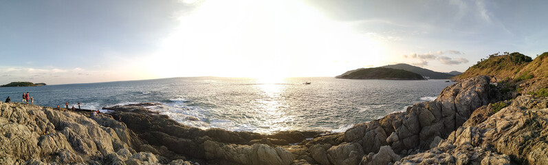 A panoramic view of the sea with rocks at sundown time.