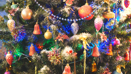 Fototapeta premium Decorated and illuminated christmas tree. Christmas lights hanging in a tree, close up