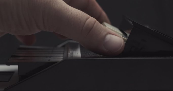 Ejecting tape and pulling it out on retro audio cassette tape player recorder
