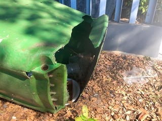 A broken bottom plastic green bin.