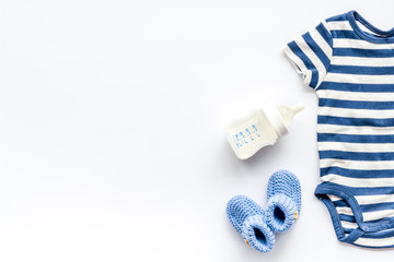 Baby background - blue color. Clothes and accessories for newborn boy on white table top-down frame copy space