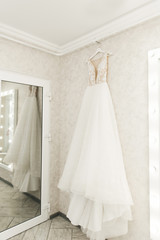 wedding dress hanging on the mirror, bride's morning