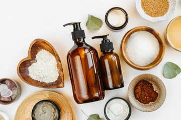 Beauty treatment ingredients for making homemade skin care cosmetic mask. Various bowl with clay, cream, essential oil and natural ingredients  on white table background. Organic spa cosmetic products