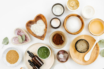 Beauty treatment ingredients for making homemade skin care cosmetic mask. Various bowl with clay, cream, essential oil and natural ingredients  on white table background. Organic spa cosmetic products